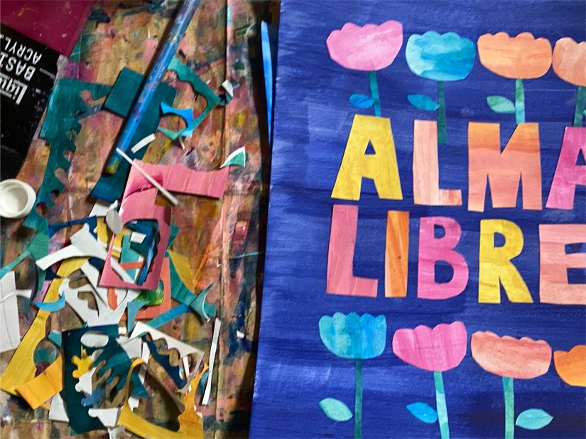 Colorful letters spelling Alma Libre on a blue background