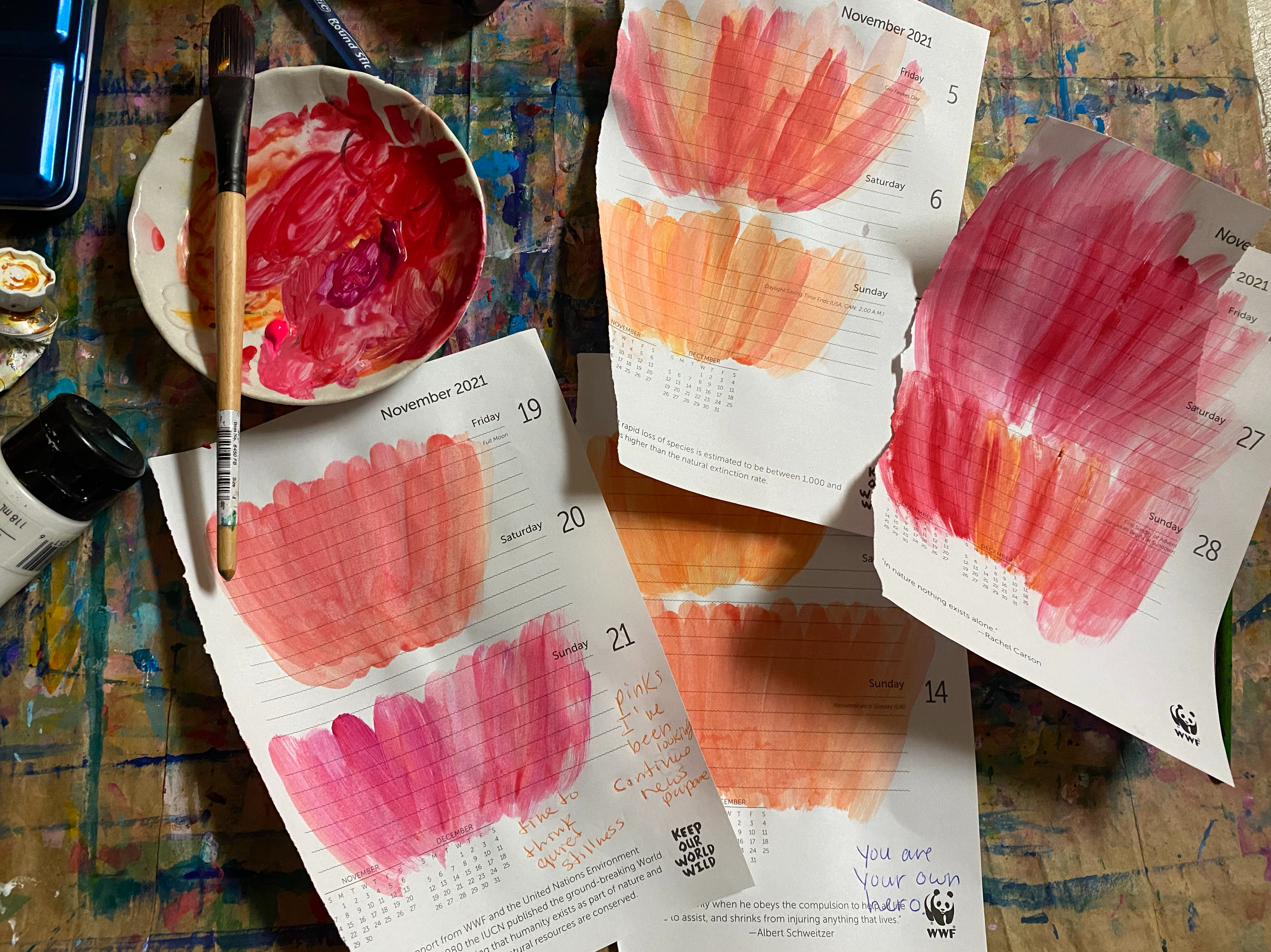 Various papers painted with vibrant orange and pink tones