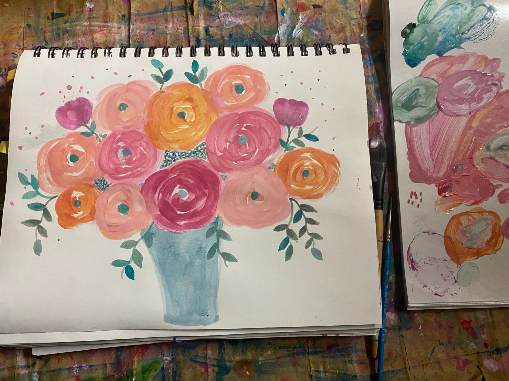 blue vase filled with pink and orange roses