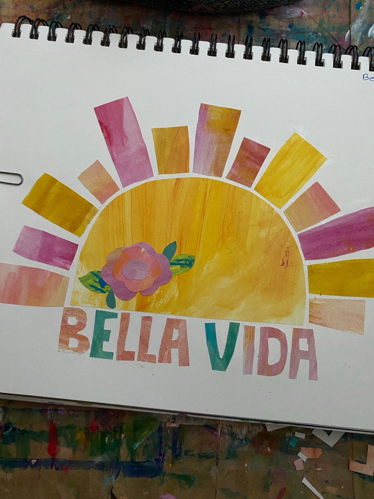 a yellow sun with pink aqnd orange rays and the words bella vida