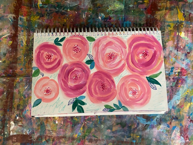 eight pink roses in various sizes with pink and blue leaves