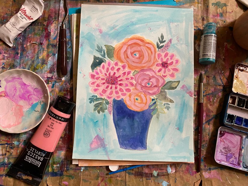 three roses and two dahlias in a blue vase