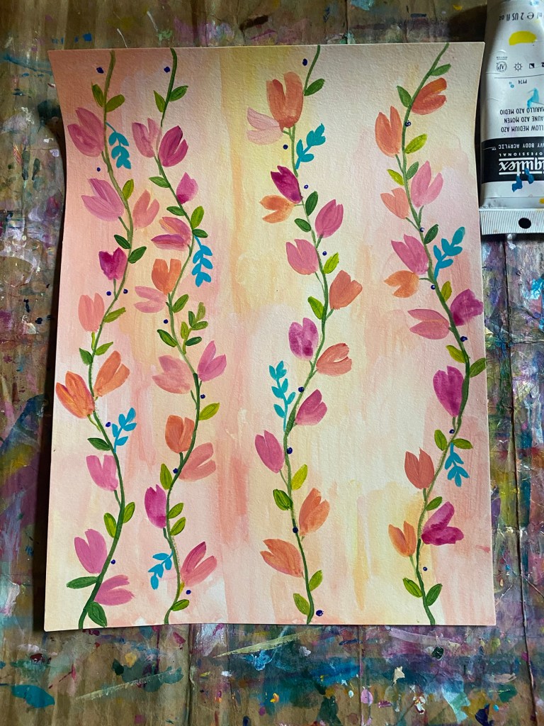 Four green vines filled with pink and peach flowers