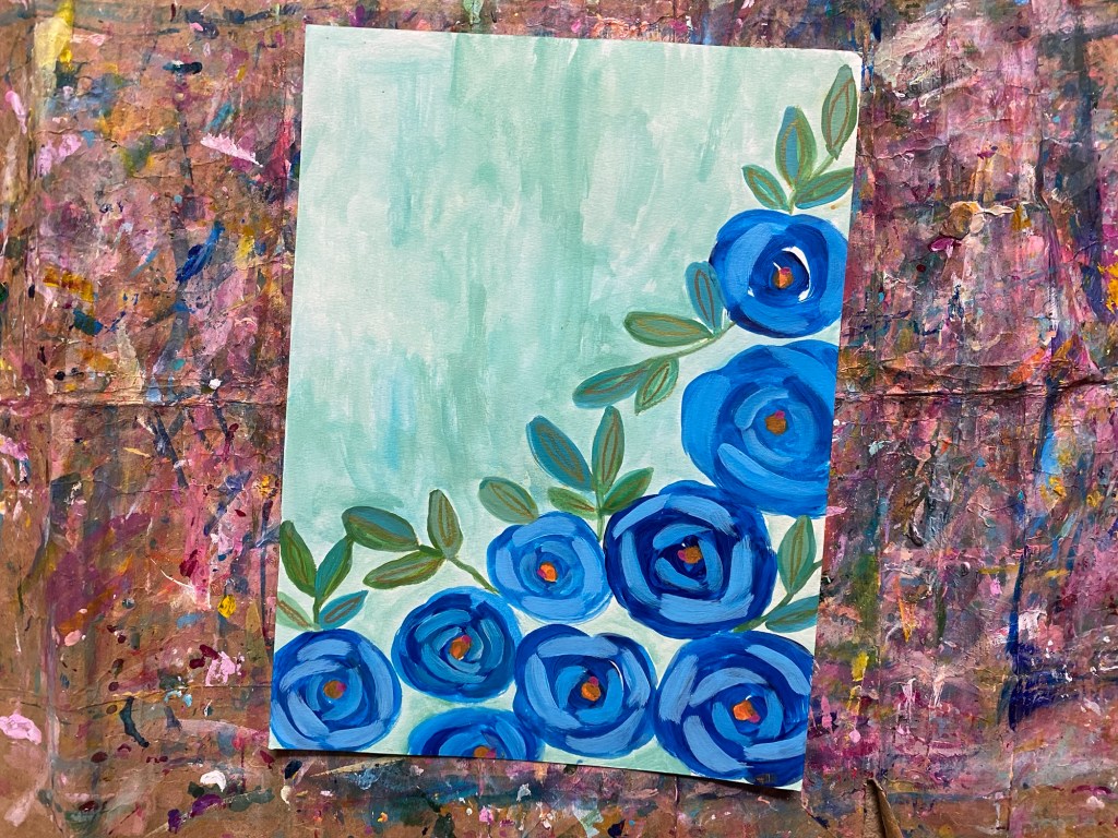 blue roses diagonally painted with green leaves on a soft blue background