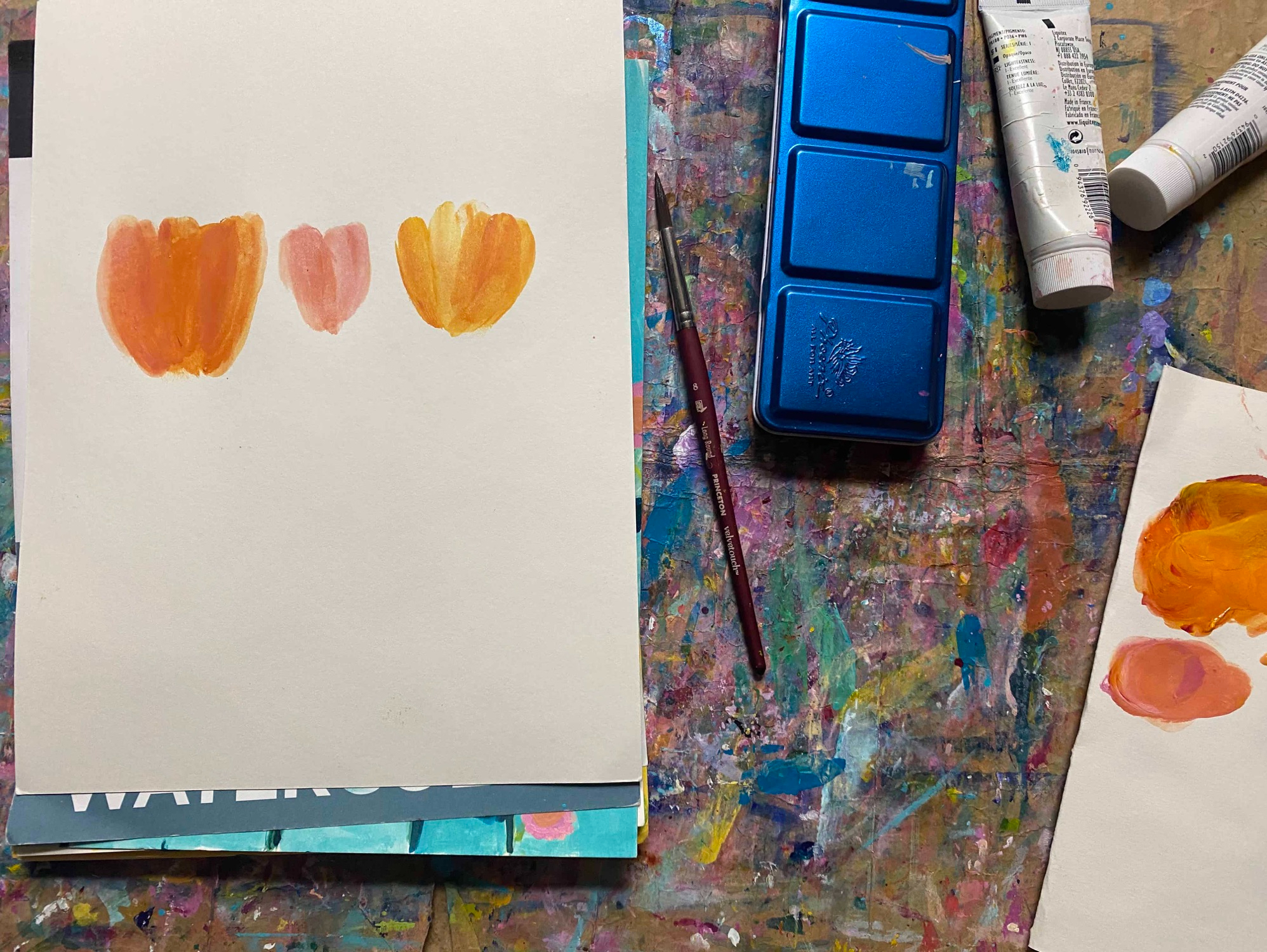 three orange and pink finger-painted flowers