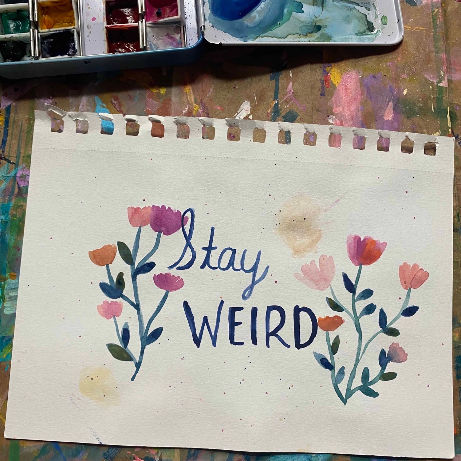 the words stay weird surrounded by pink wildflowers