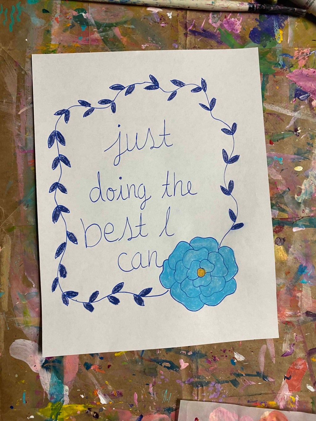 a blue leaf vine with a blue flower and inside are the words just doing the best I can